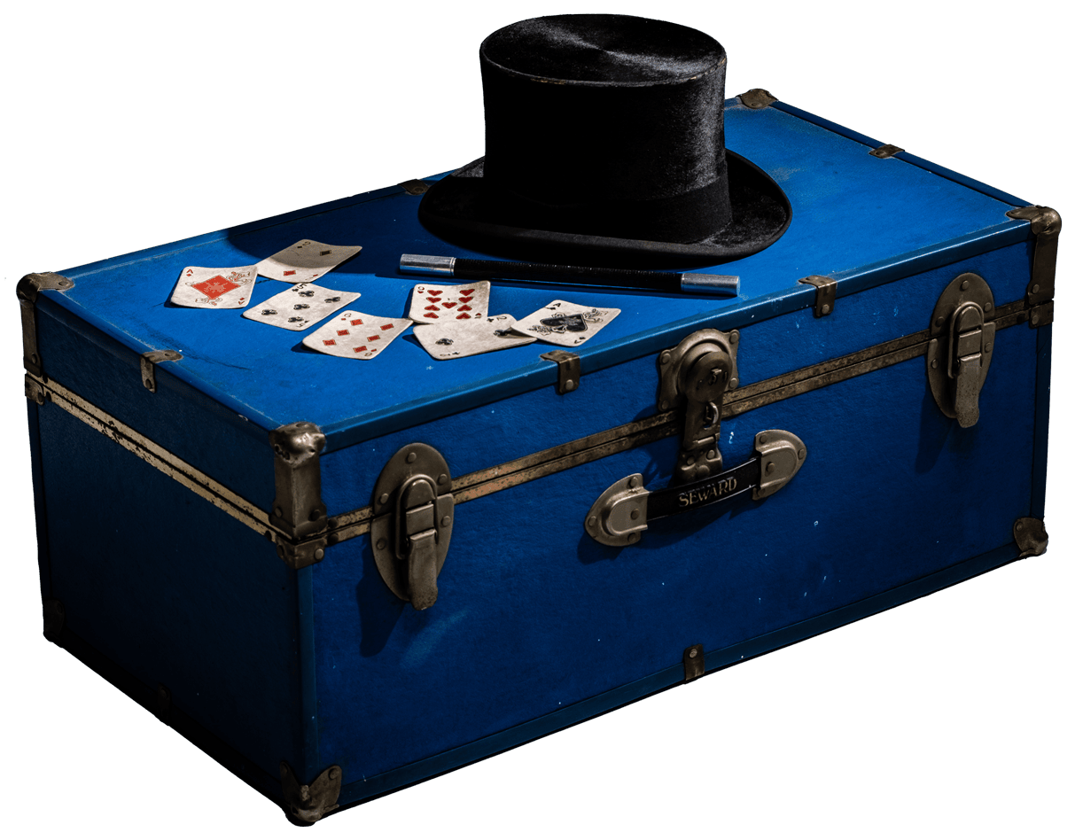 cartas, vara mágica y galera sobre un baúl cerrado | MAGO